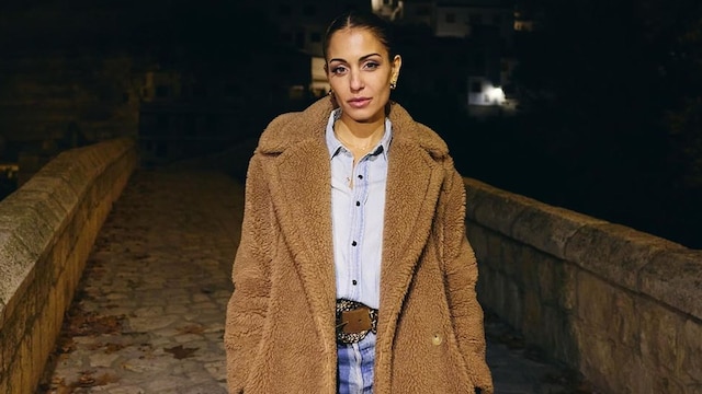 Plano entero de Hiba Abouk posando con abrigo de borreguito marrón