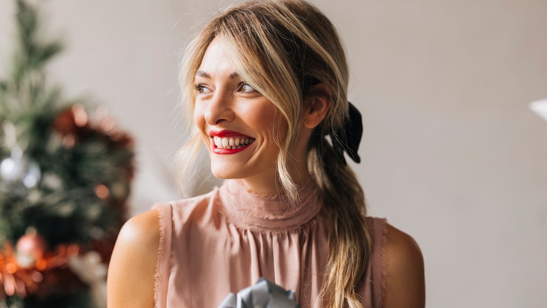 Mujer feliz con un regalo en las manos en Navidad