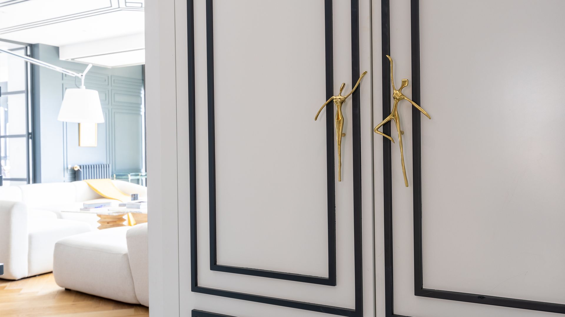 Puerta de armario con molduras en color azul y tiradores con forma de persona dorados