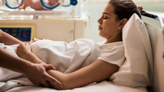 young mother resting in maternity room after childbirth 