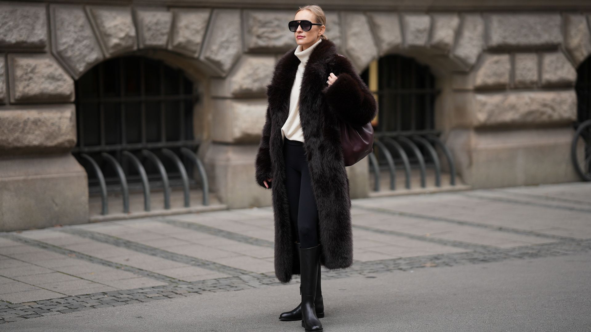 Marlies Pia Pfeifhofer con abrigo de pelo marrón, jersey de cuello vuelto y botas altas en Munich