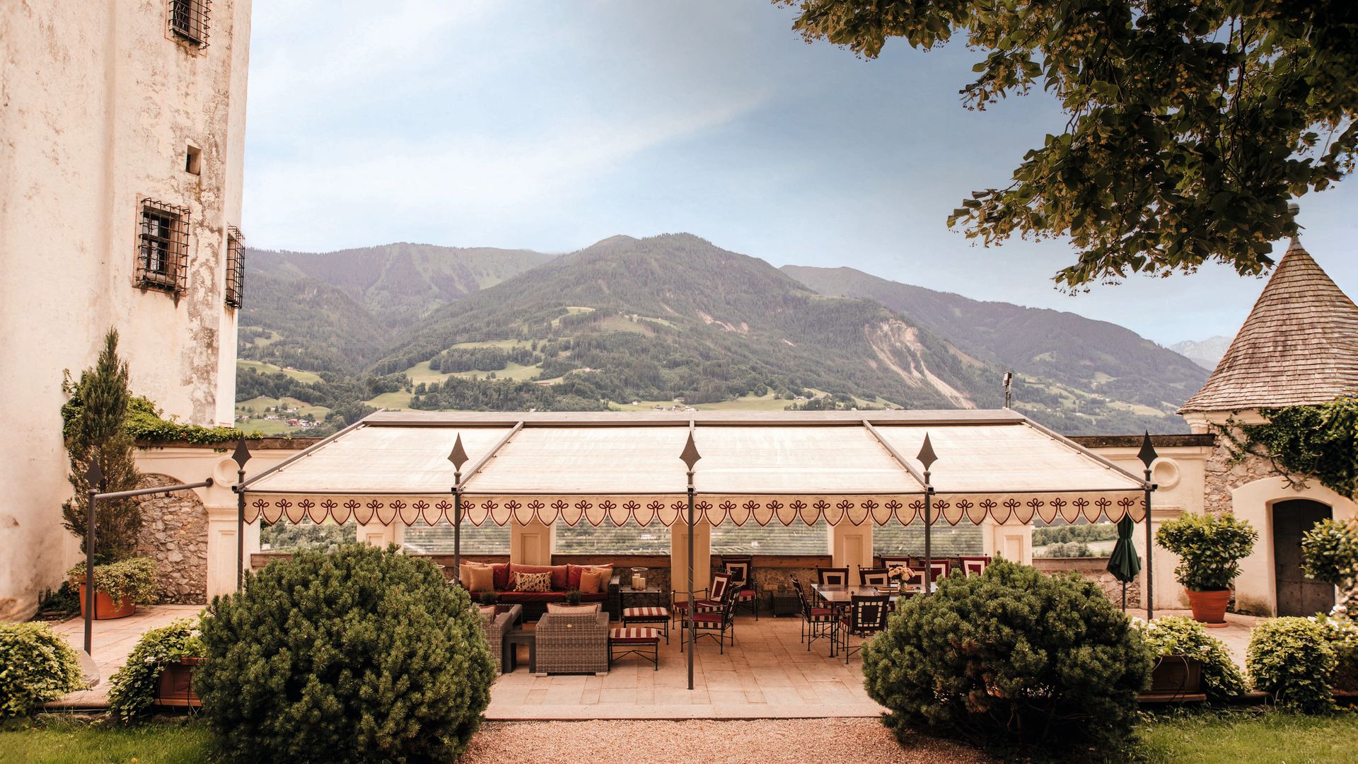 Terraza al aire libre con muebles elegantes y vista a las montañas.
