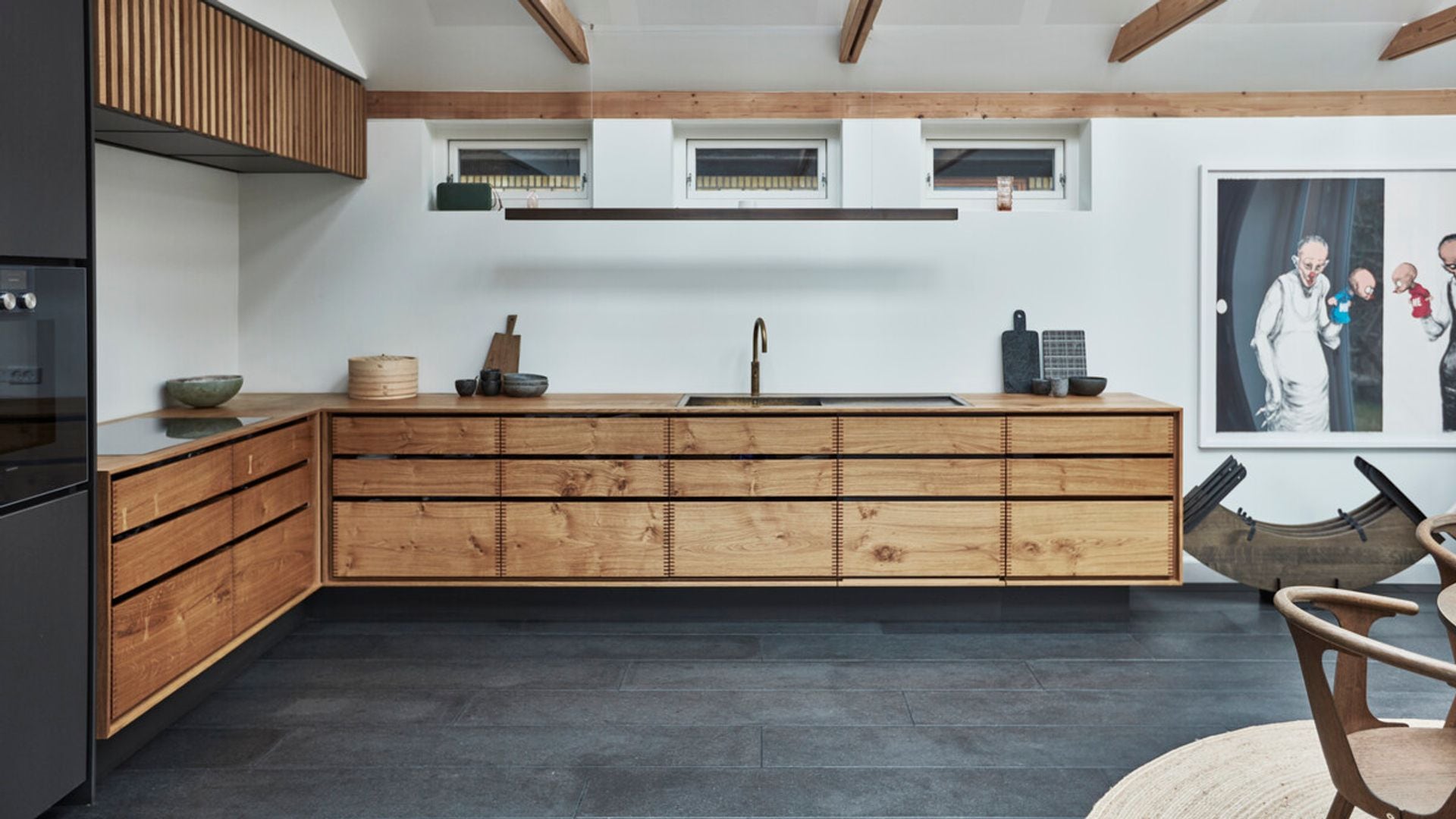 Cocina con muebles de madera y suelo y electrodomésticos negros
