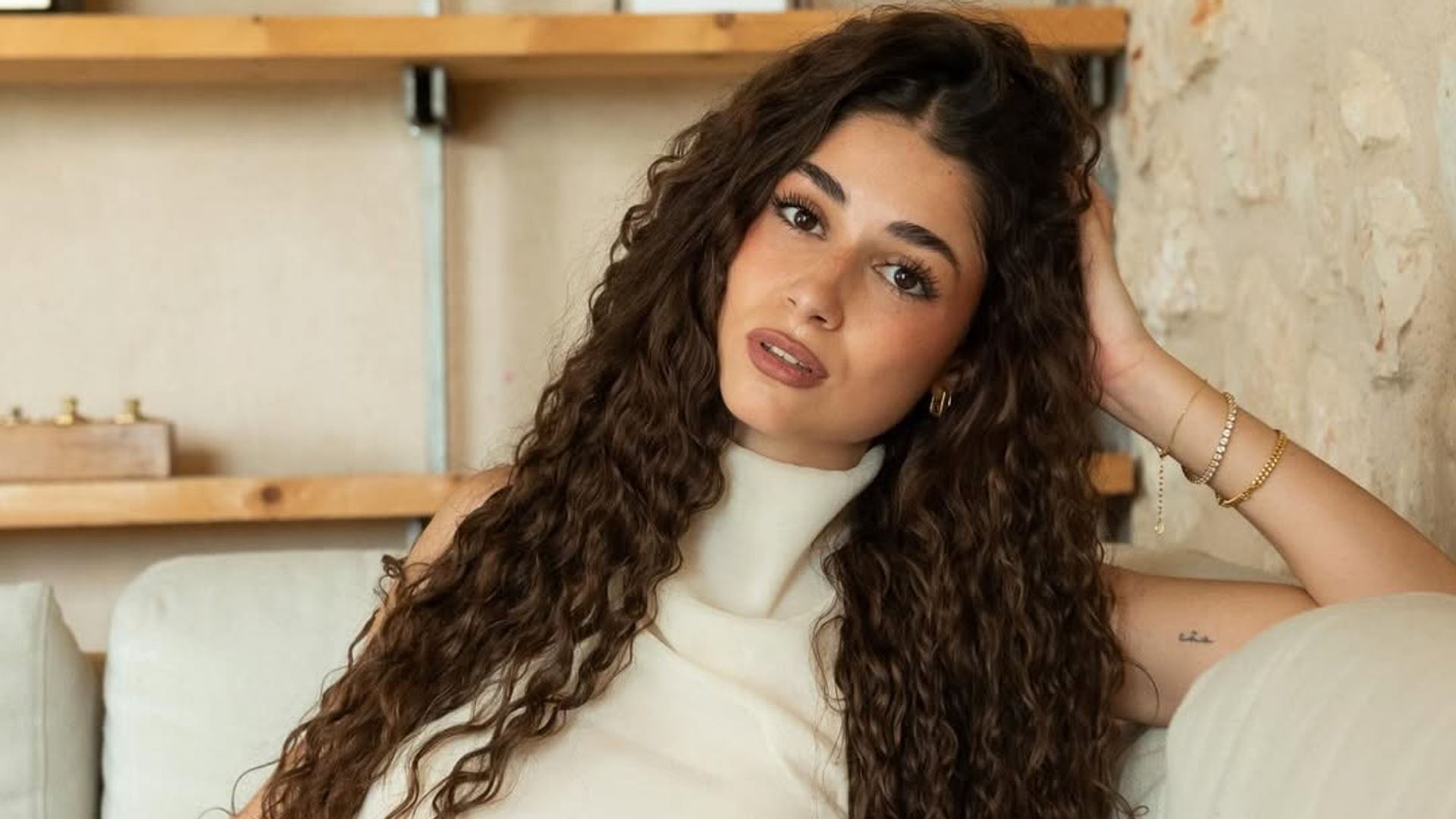 Alejandra Díaz con pelo rizado largo y definido en tono castaño oscuro