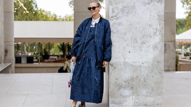 Mujer rubia con un vestido largo denim, cazadora a juego y bailarinas plateadas en la Paris Fashion Week