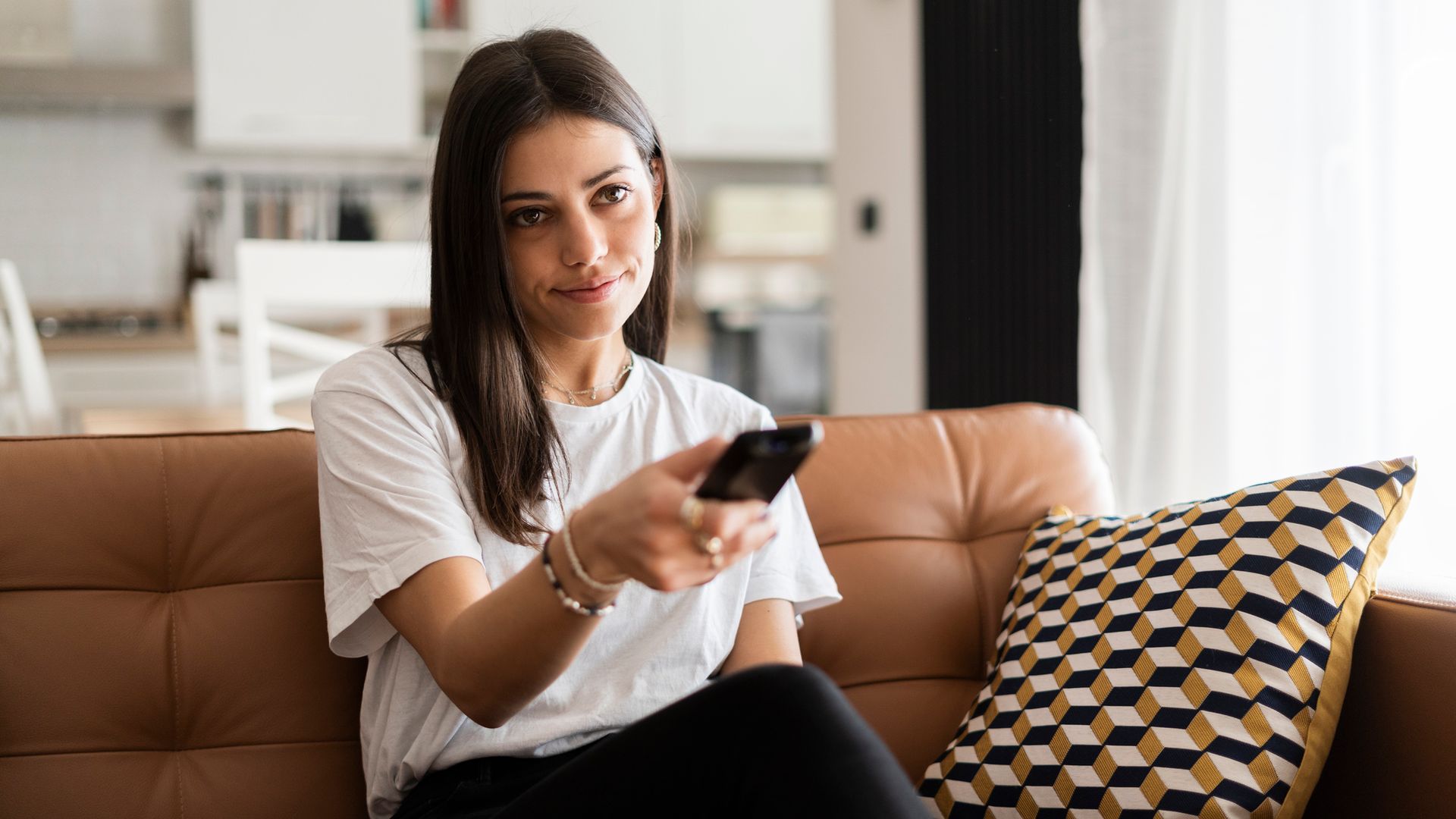 Mujer con un mando a distancia viendo la televisión