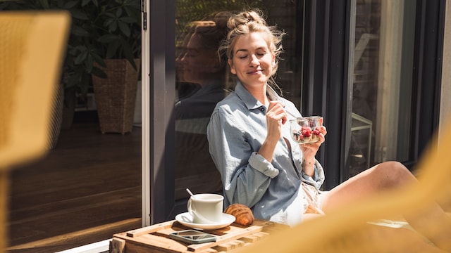 Mujer disfrutando de un desayuno saludable en la terraza