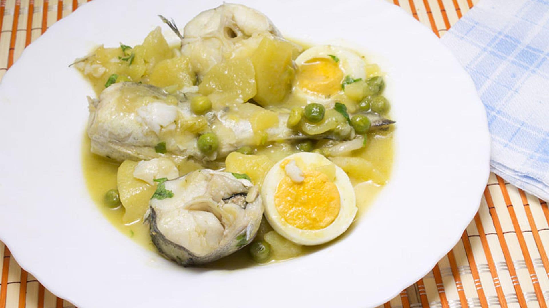 Merluza en salsa con patatas, guisantes y huevo duro
