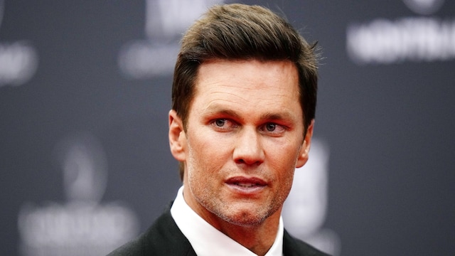 Primer plano de Tom Brady con traje negro y corbata de lunares