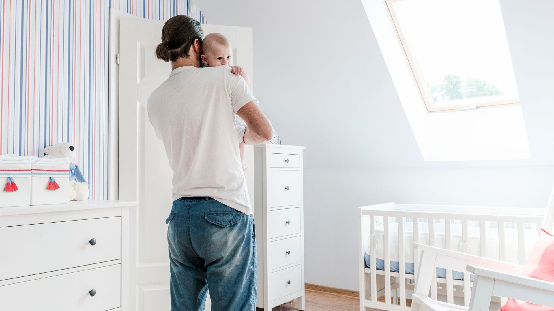 Padre lleva a su bebé a la cuna a dormir