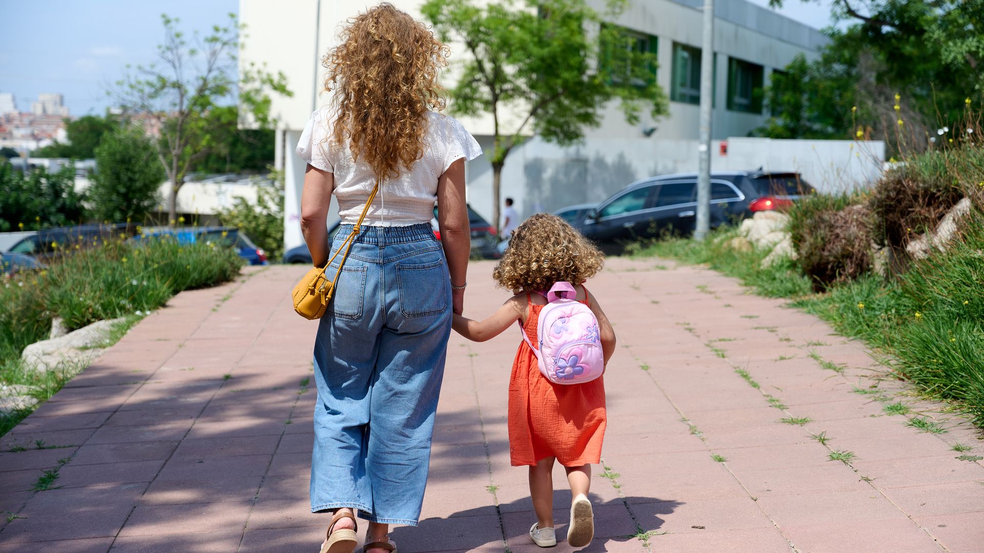 Una madre llevando a su hija al colegio