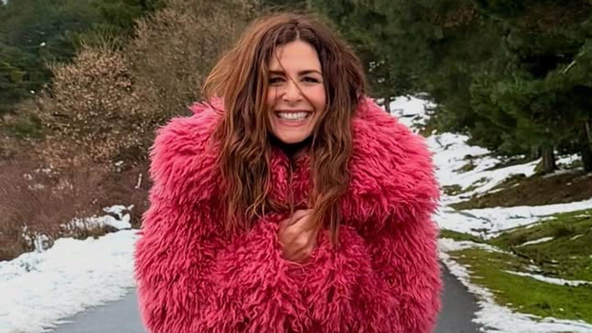 Nuria Roca con abrigo rosa efecto pelo en la nieve.