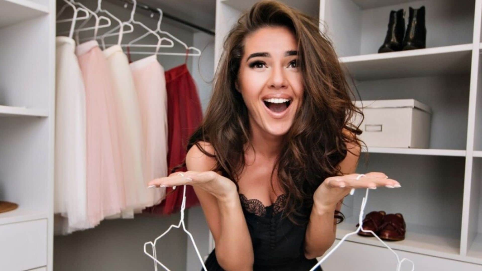 Mujer mirando a la cámara sonriendo en su armario.