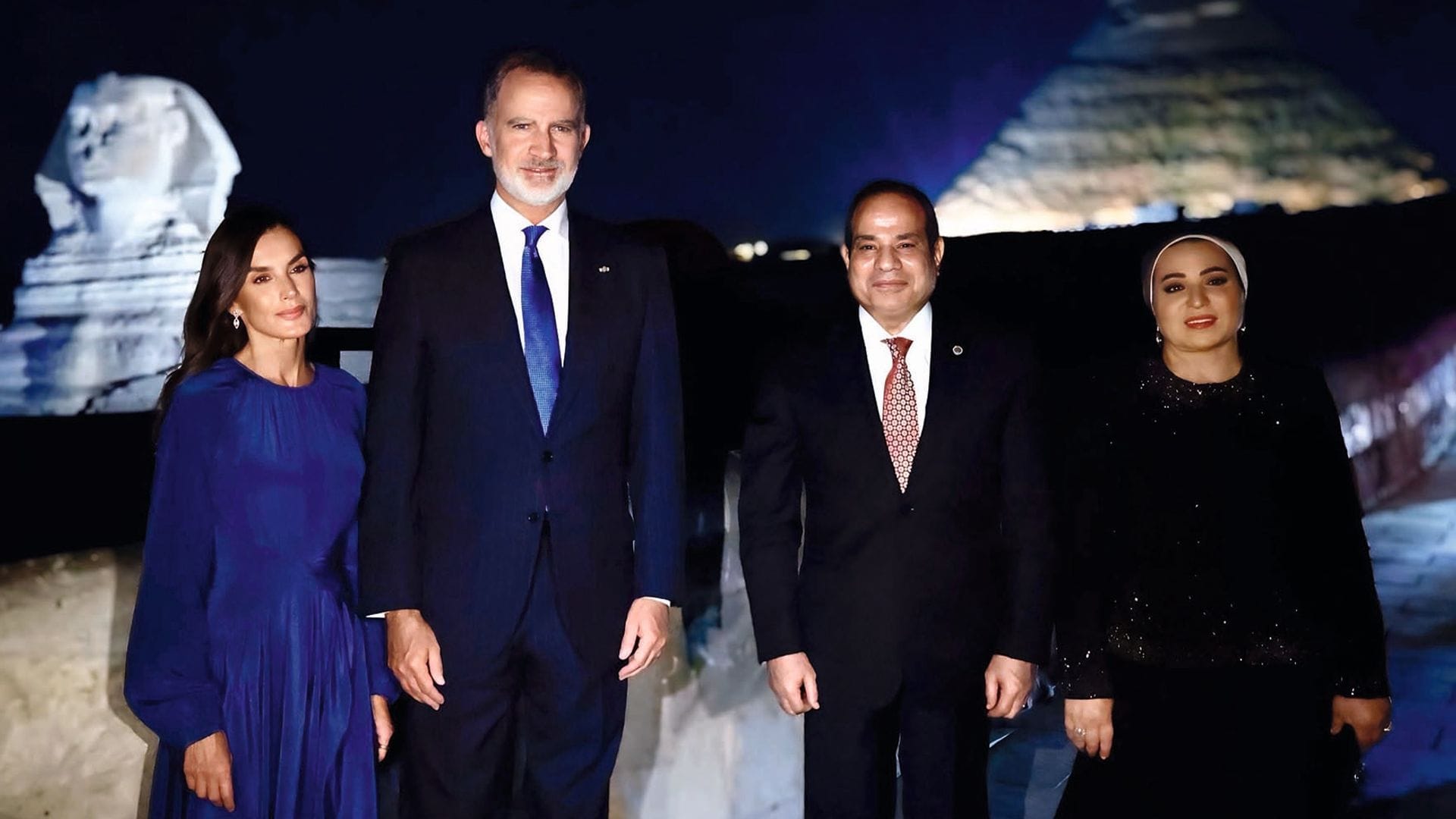 Felipe VI y doña Letizia, con un vestido azul "Harbour" de la firma británica Joseph, concluyeron el primer día de visita con una sorpresa mejor: cena ante las pirámides egipcias iluminadas por empresas españolas. Aquí, junto al Presidente y la primera dama, ante la pirámide de Keops y la Gran Esfinge