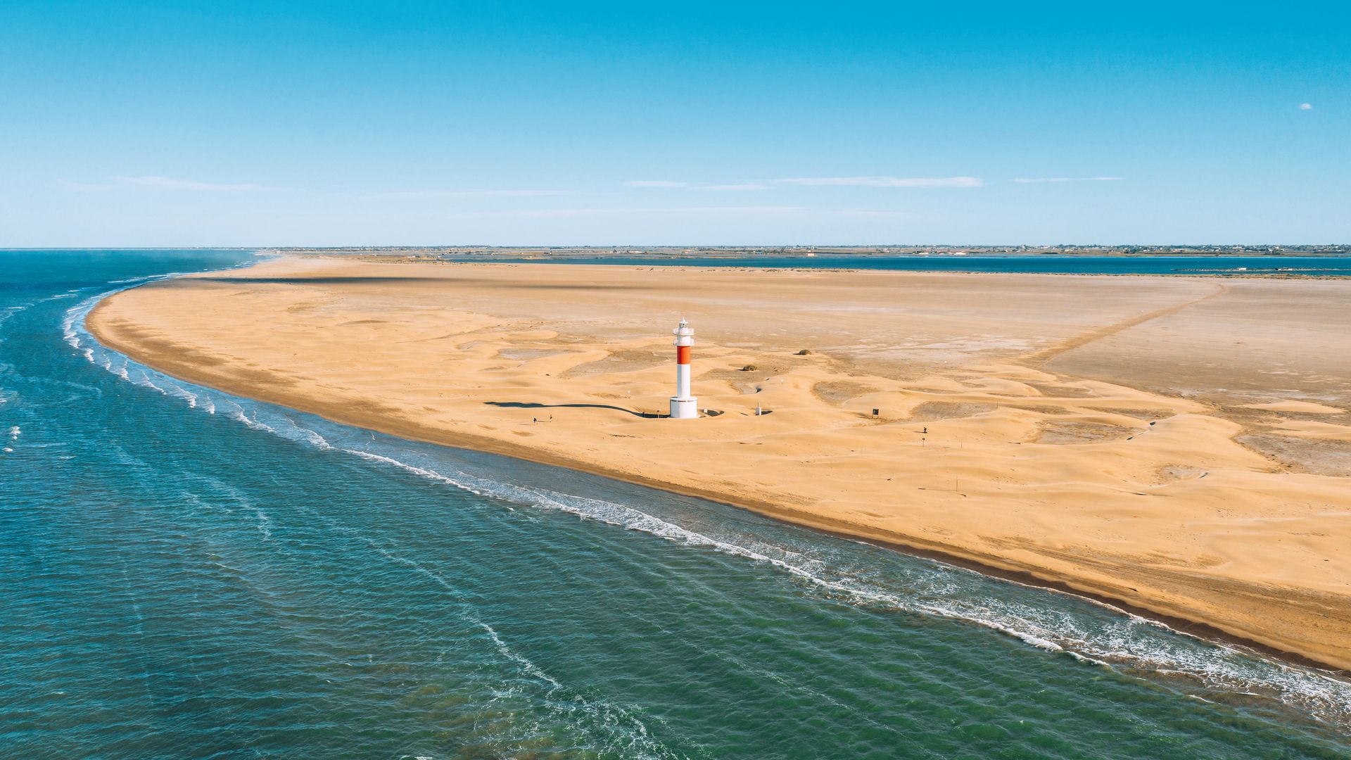Playa y faro en la Punta del Fangar en el delta del Ebro, Tarragona