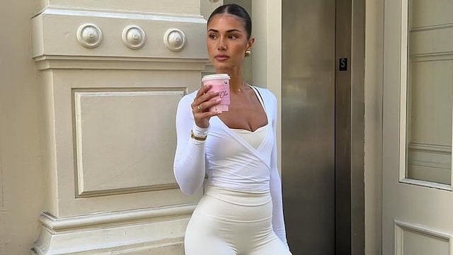 Mujer conjunto blanco fitness con cafe en la mano