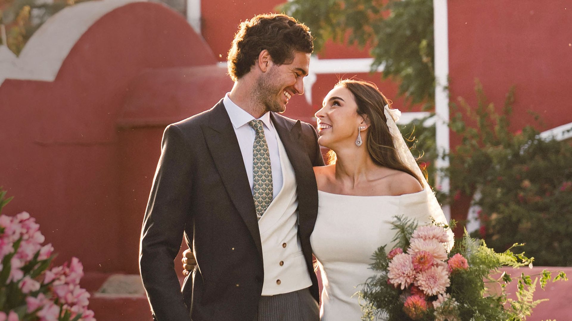 La novia lució un peinado muy natural —melena suelta con semirrecogido—, decorado con una tiara antigua y mantilla. Según ha confirmado ¡HOLA!, sumó elementos con historia a su gran día, como un camisón rosa de su abuela para los preparativos y un espectacular ramo en cascada de ramajes verdes y flores rosas