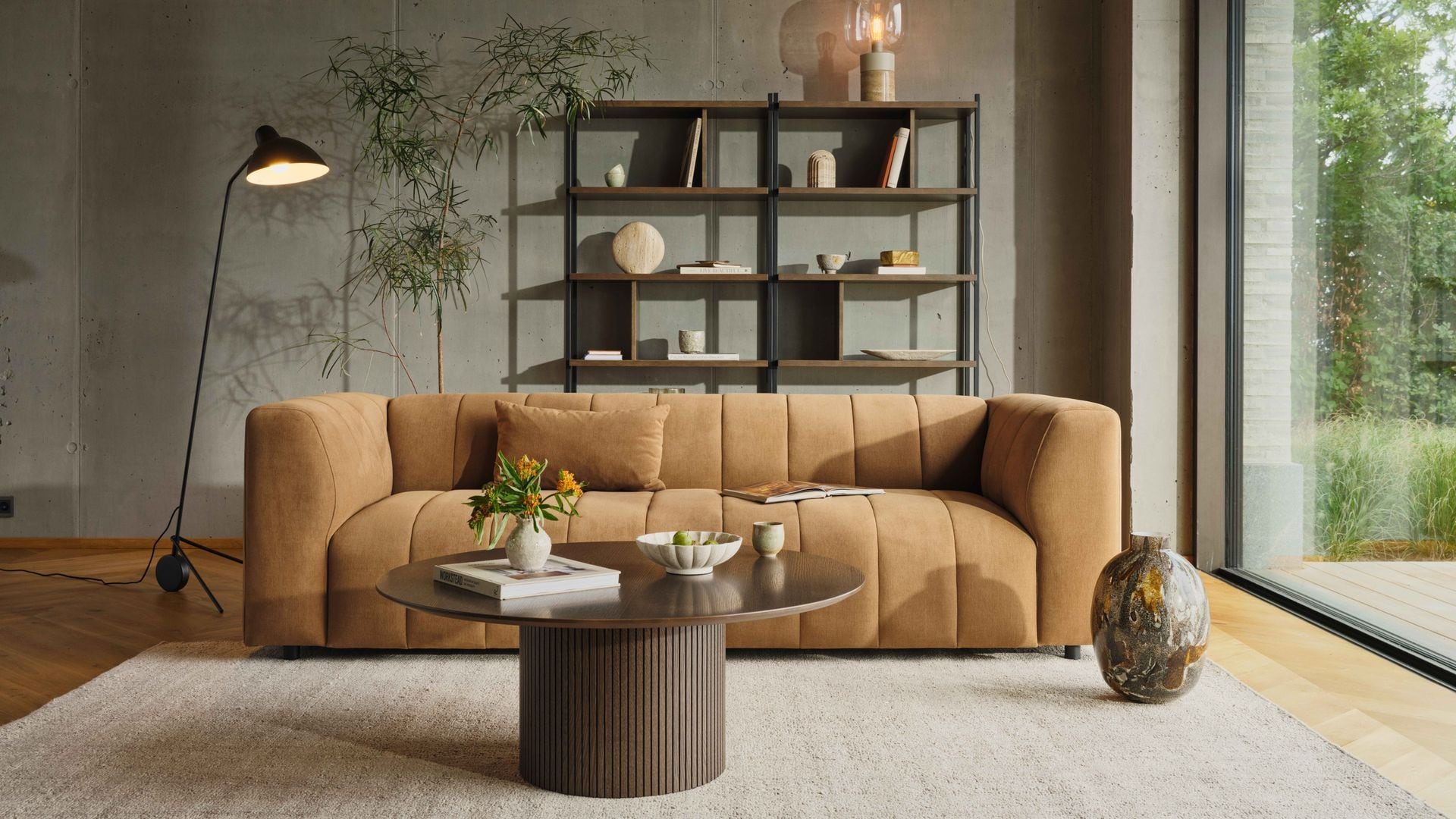 Salón con gran ventanal, sofá marrón, alfombra beige, mesa de centro, lámpara de pie y estantería 