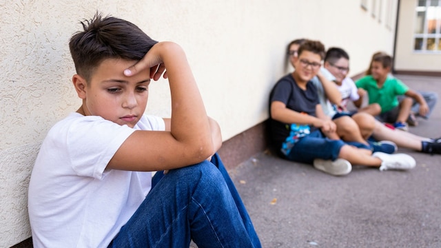 Niño triste en el recreo porque sus compañeros se burlan de él