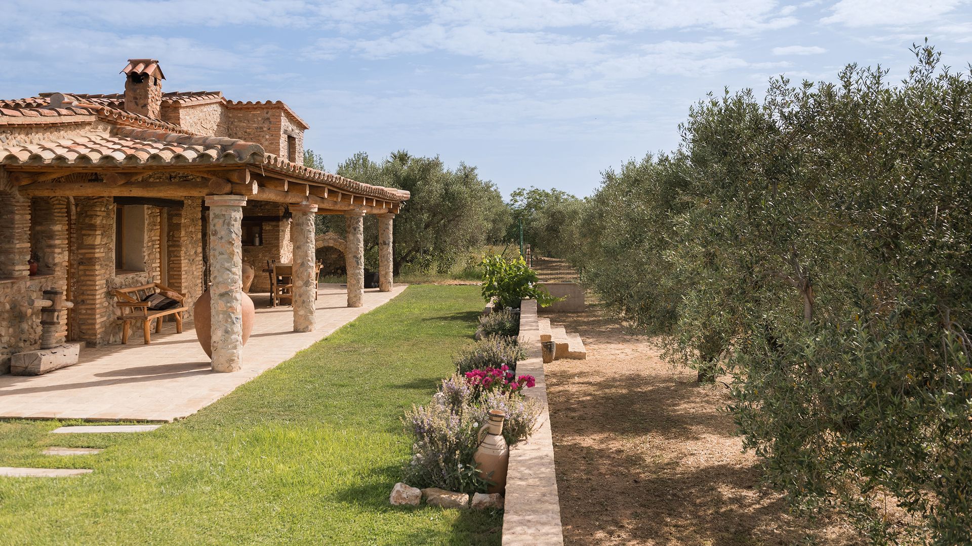 Masía catalana de piedra y jardín con olivos 