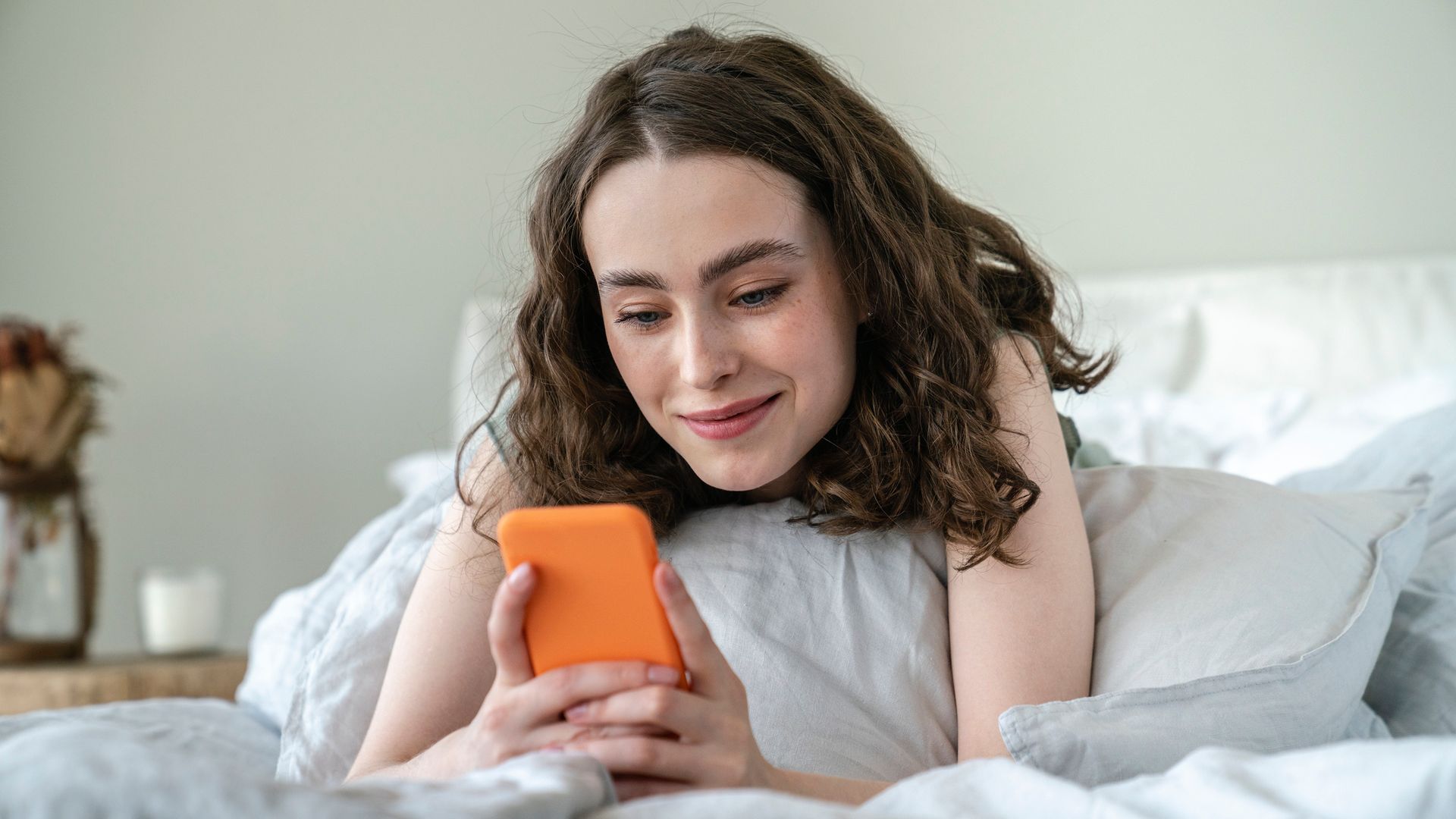 Mujer en la cama mirando el móvil