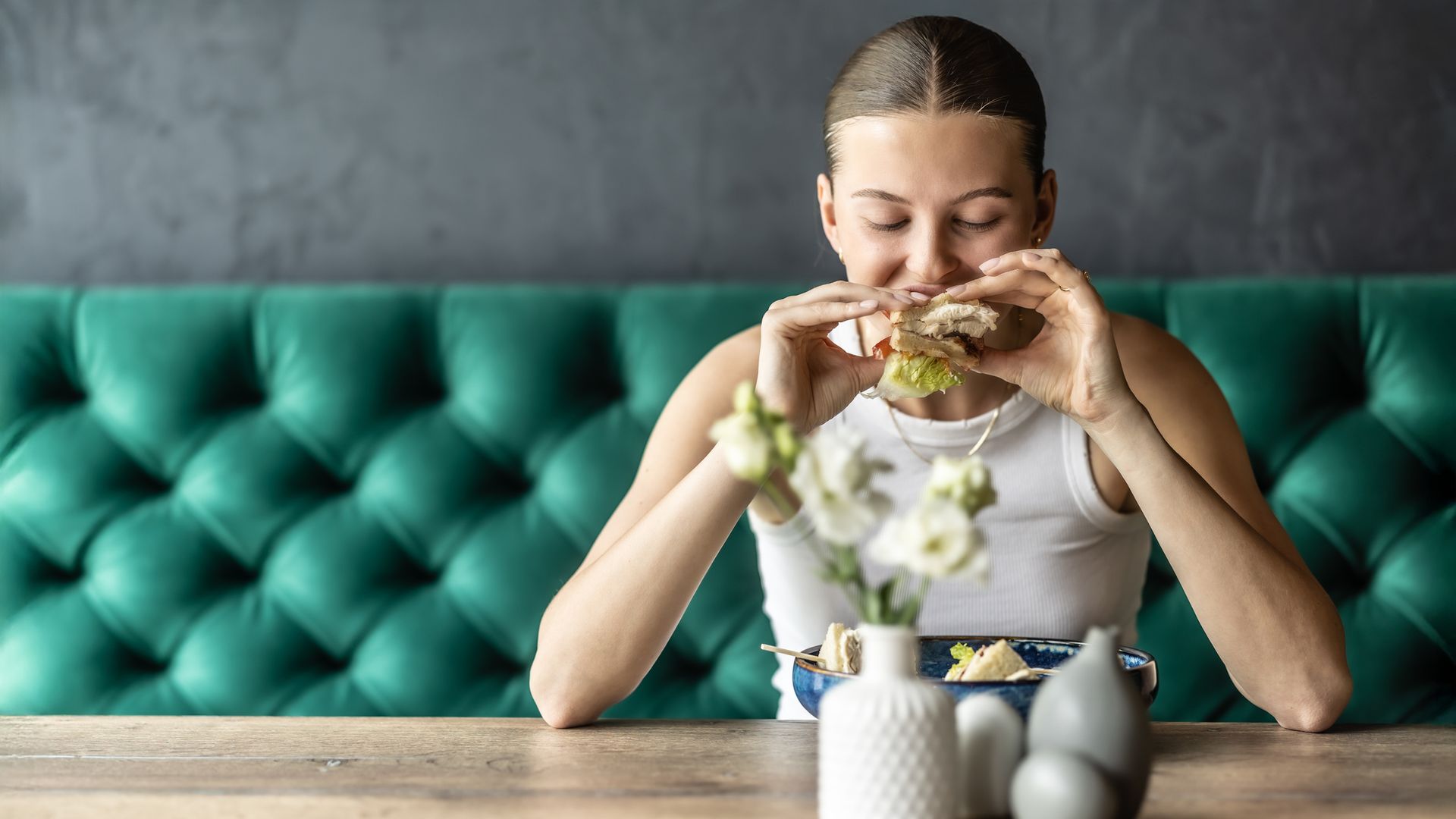 Mujer joven comiendo una hamburguesa