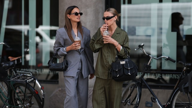 Anna y Alessa Winter con conjuntos de traje bebiendo café en la calle