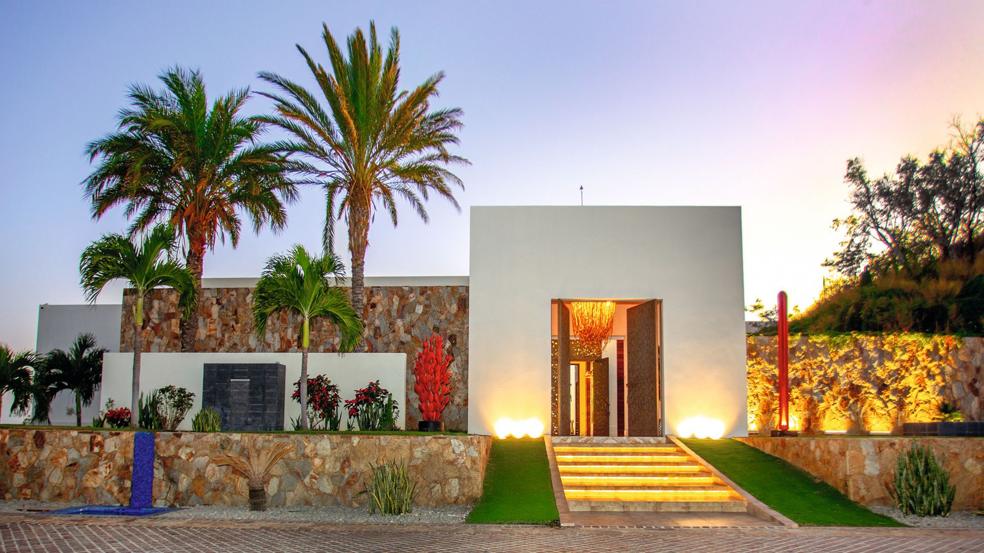 La entrada principal está rodeada de cactus rojos de Marruecos y exóticas palmeras