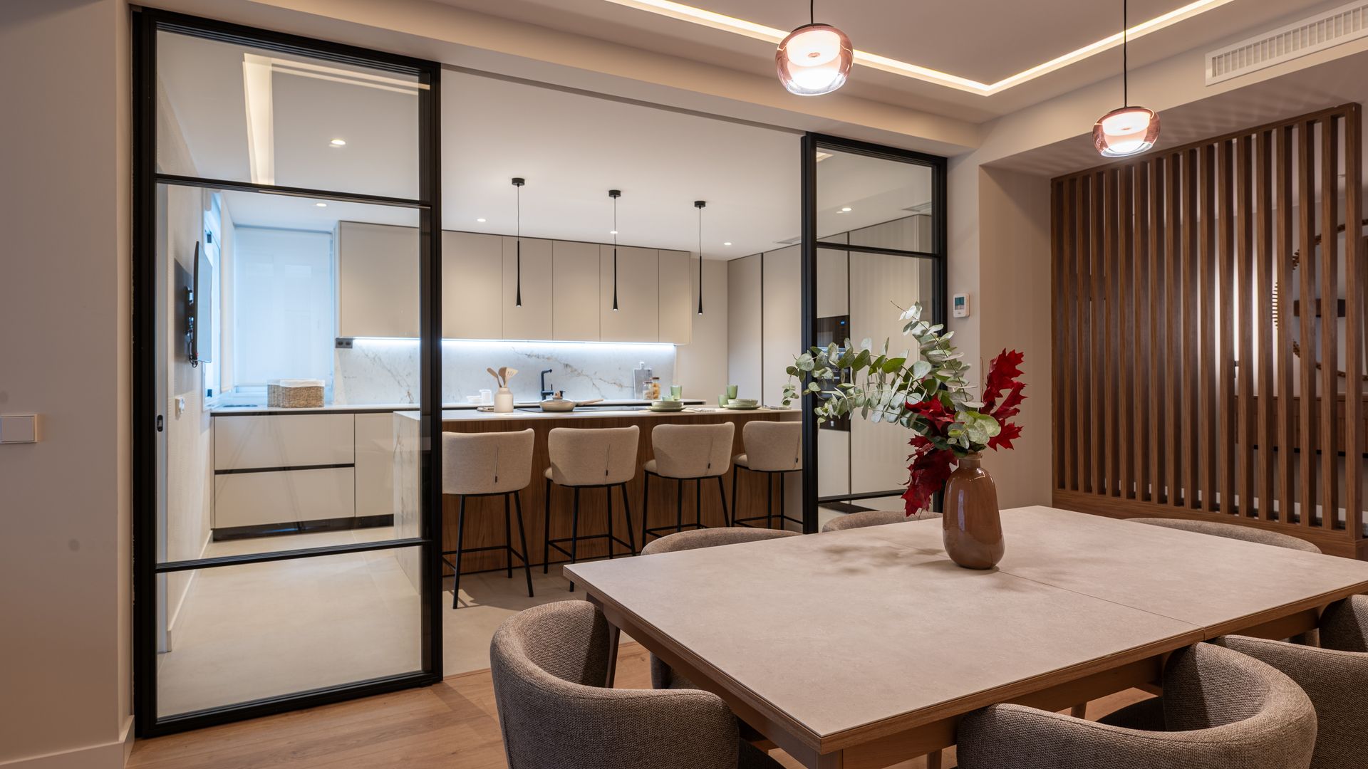 Cocina abierta separada del comedor con tabiques de cristal con marcos negros 