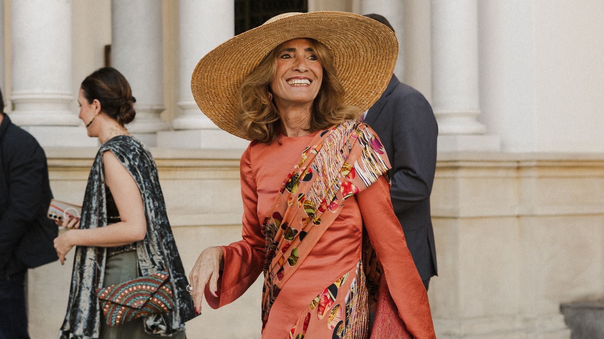 El look más comentado de esta boda en Sevilla fue el de la madre de la novia, con vestido coral asimétrico y pamela de rafia