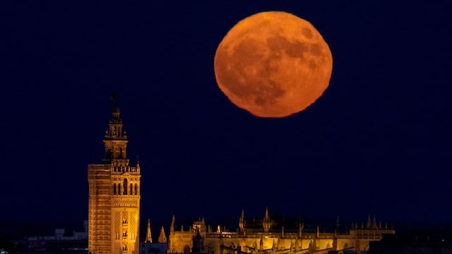 La Luna del Esturión se alza tras la Giralda de Sevilla, tiñendo de magia el cielo andaluz en una noche de agosto