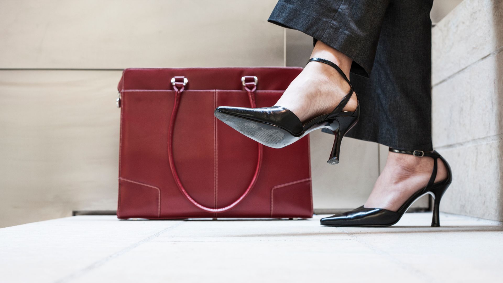 vista de los zapatos de una mujer en el suelo, junto a su bolso