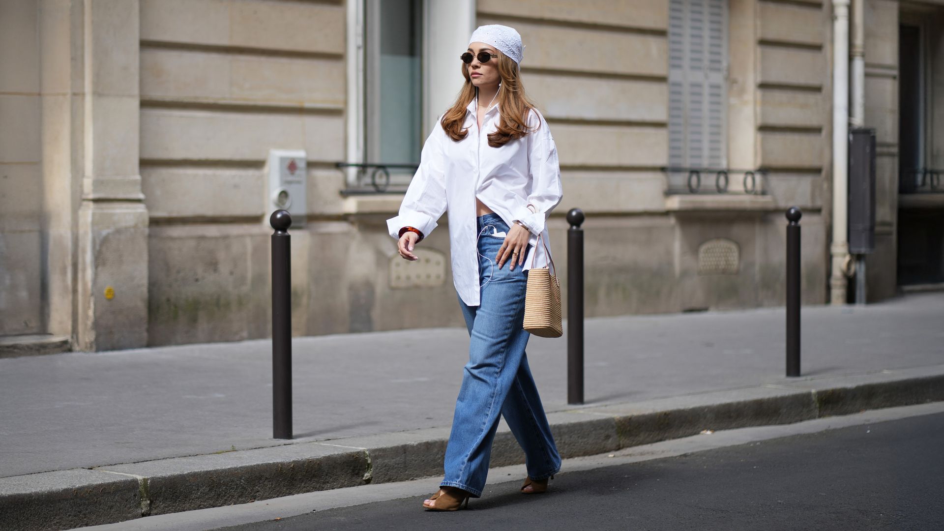 Merve Gorgoz con vaqueros, camisa blanca y sandalias de tacón en una sesión de fotos en París