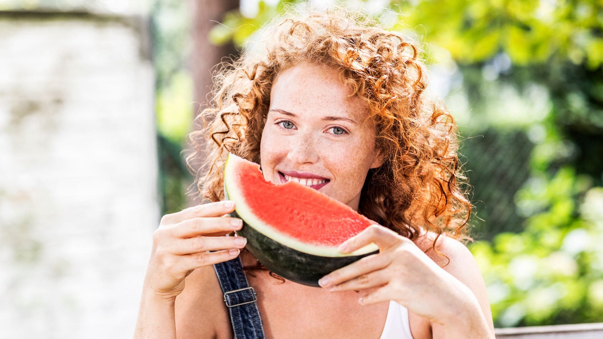 Mujer comiendo una sandía en verano