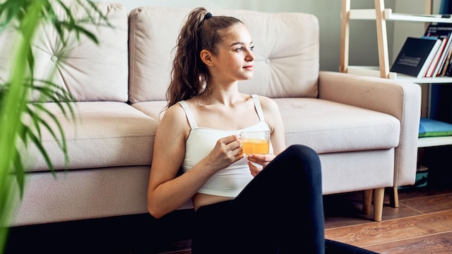 mujer tomando una infusión después de entrenar en casa