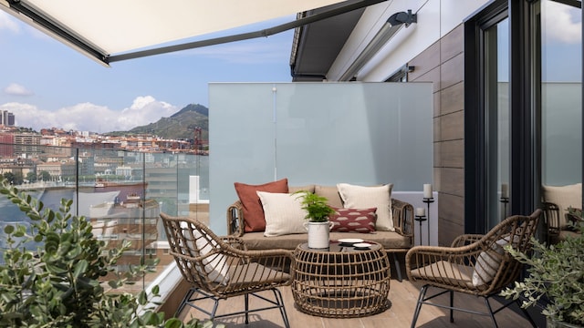 Terraza con barandilla de cristal, separador de cristal al ácido, muebles de fibras, toldo, plantas y velas