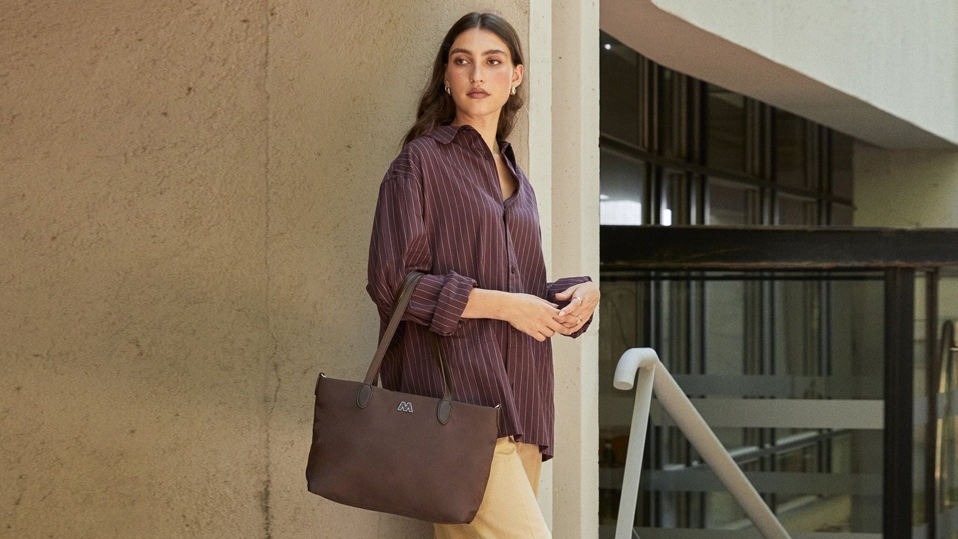 Mujer con pantalón ancho, camisa de rayas y bolso shopper de Misako