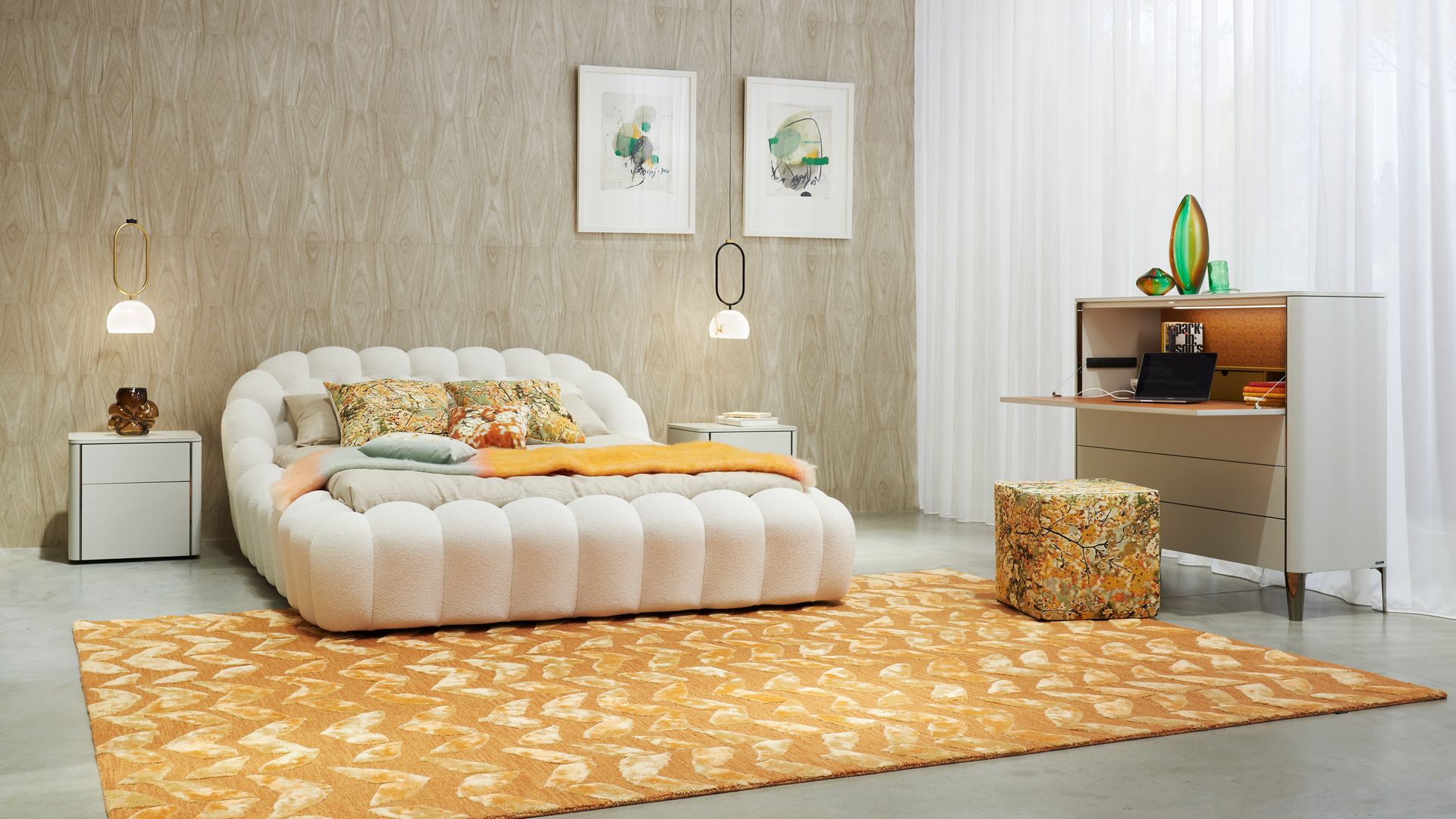 Dormitorio con cama tapizada, cabecero tapizado, alfombra amarilla, secreter de madera, puff