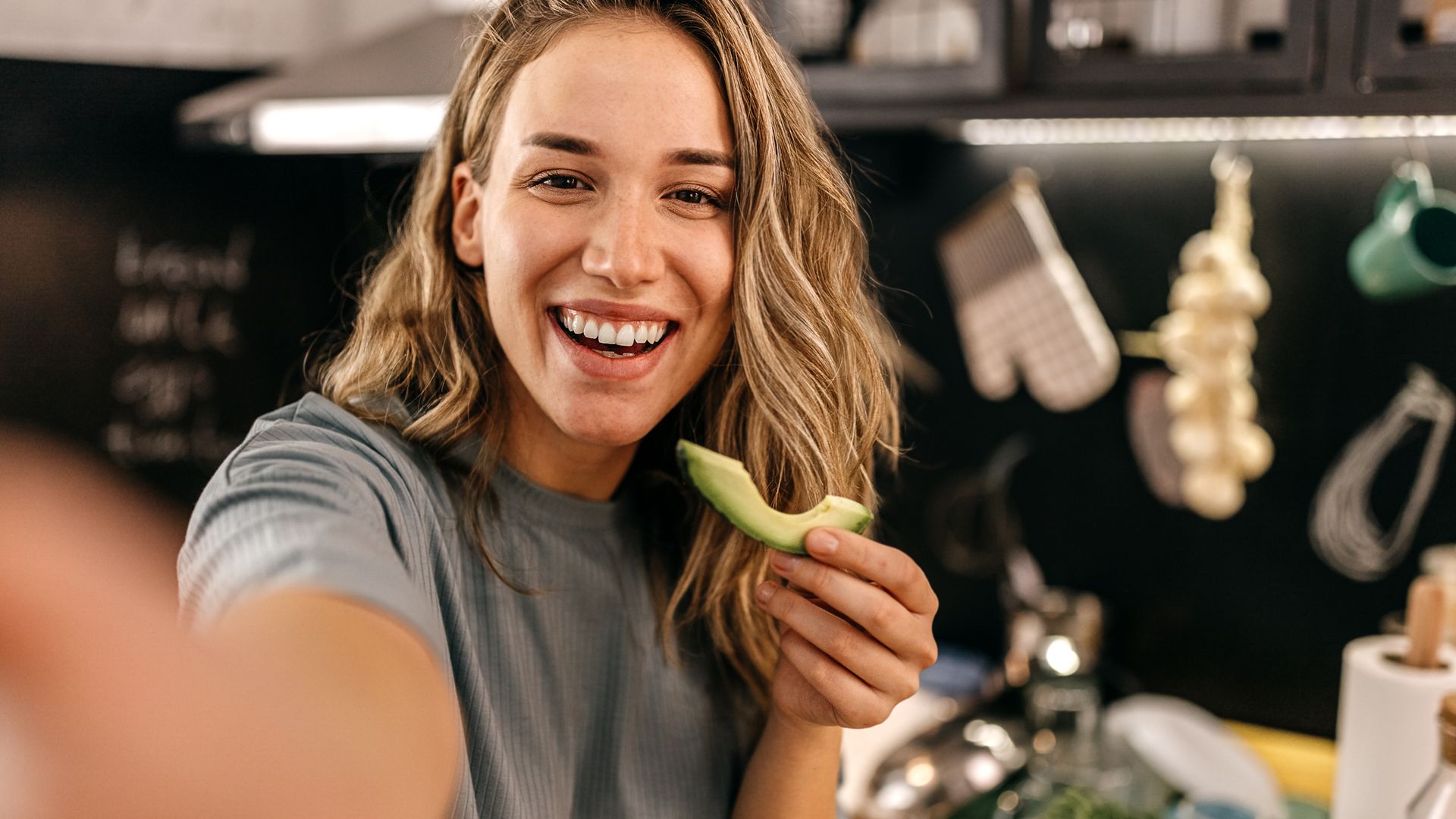Mujer divertida comiendo aguacate