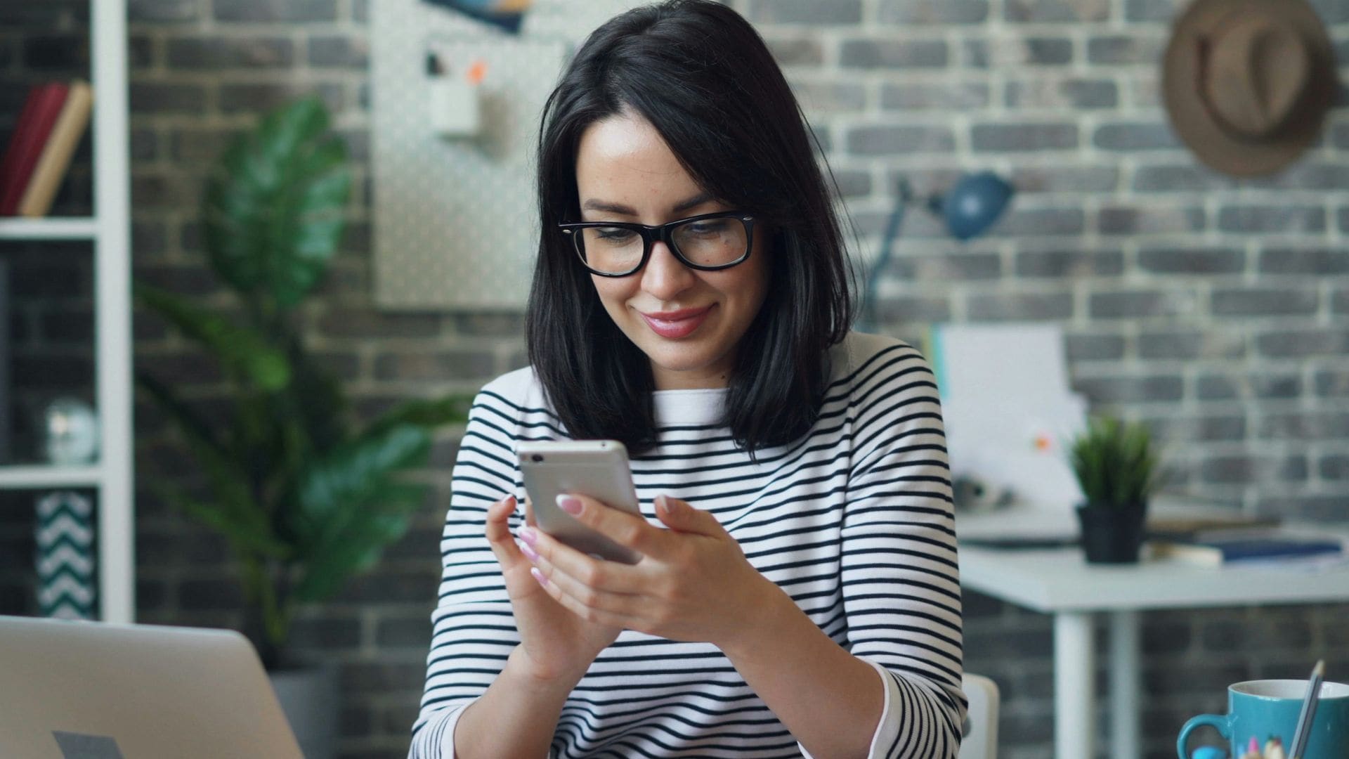 Mujer en su despacho comprando online con el teléfono movil