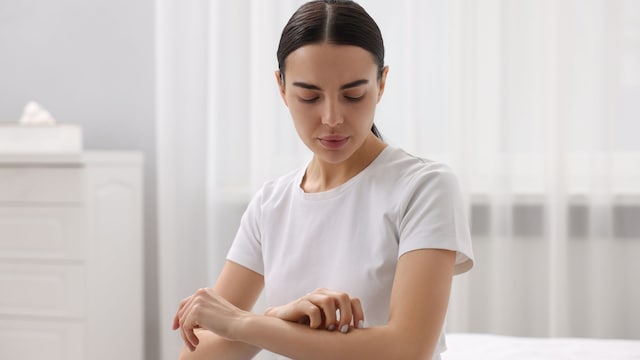 mujer rascándose la piel, con picor