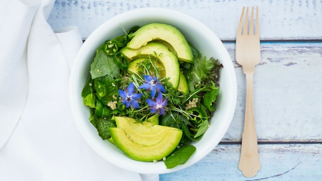 Detox Bowl of different lettuces, vegetables, cress, quinoa, avocado and starflowers