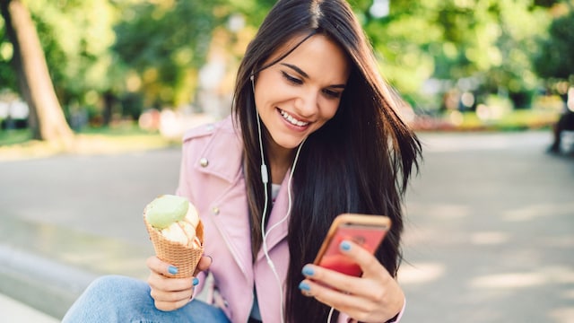 mujer hablando por teléfono mientras se come un helado