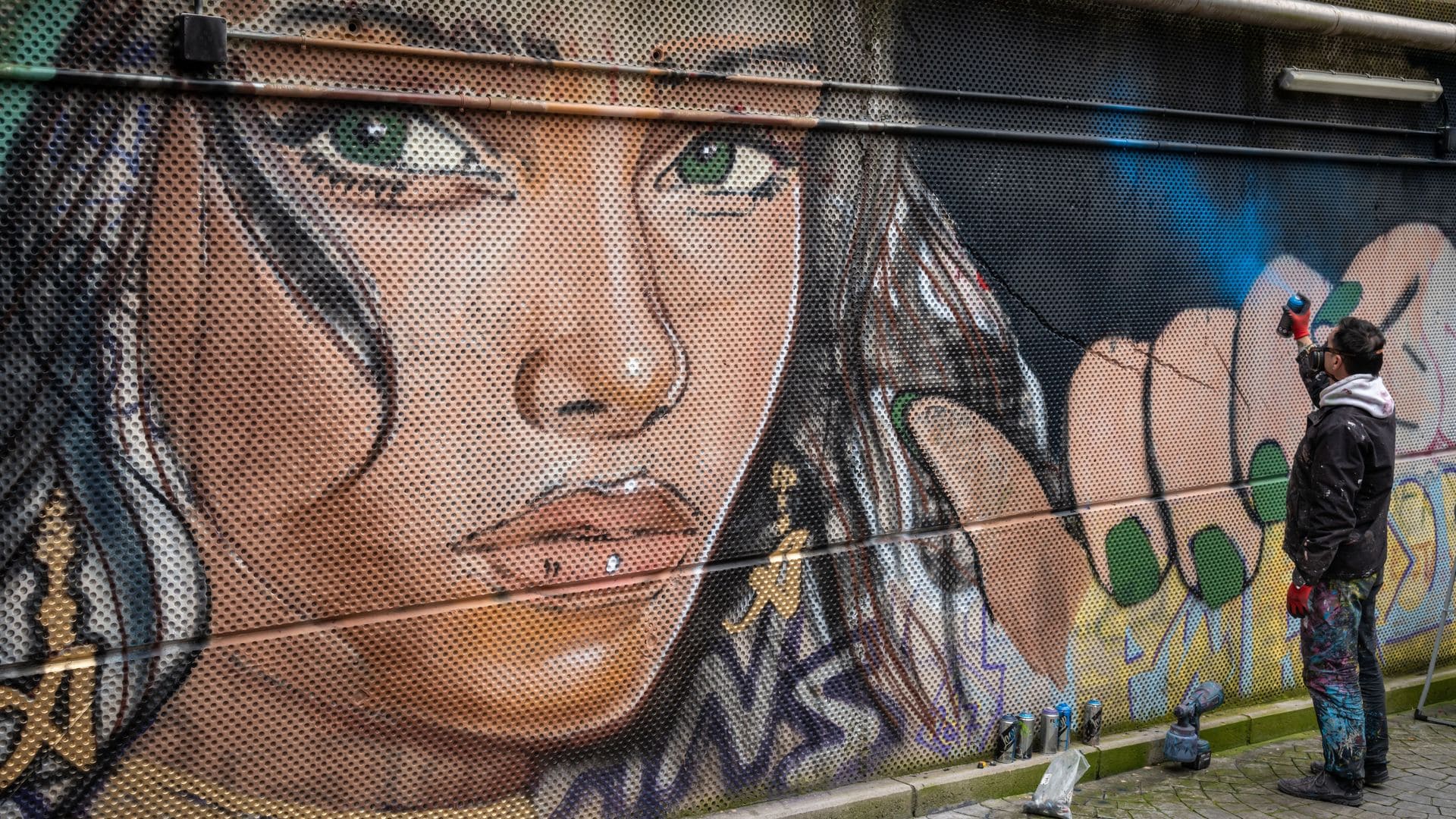 Intervención artística del muralista Sfhir en Lavapiés para CALLE 25
