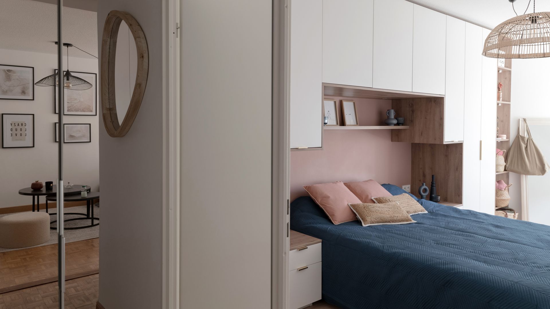 Dormitorio con armario a medida en la pared del cabecero, ropa de cama azul, mueble a medida blanco y pared rosa