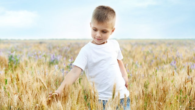 Niño en mitad de un campo feliz