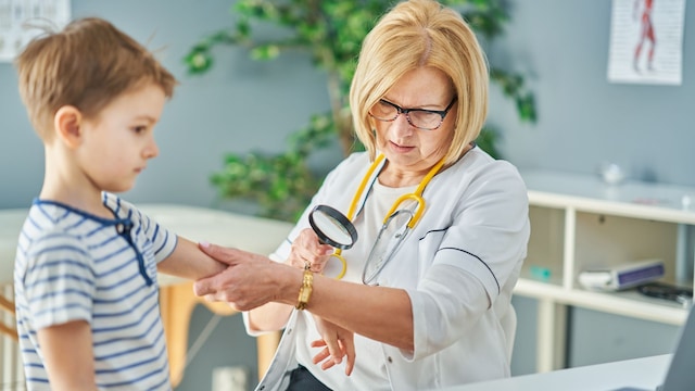 Pediatra examinando la piel de un niño