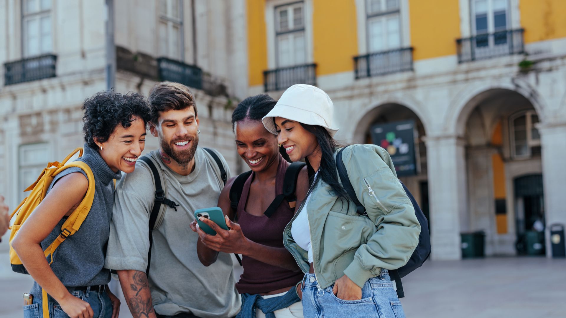 Un grupo de turistas en la ciudad portuguesa de Lisboa organizando su viaje con un teléfono móvil