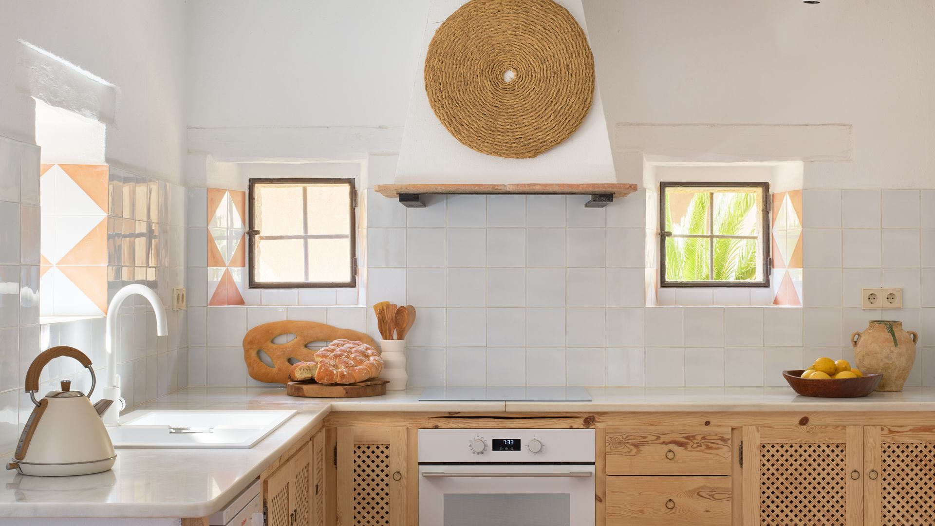 Cocina blanca y de madera con azulejos blancos, campana de obra y muebles de madera acanalada