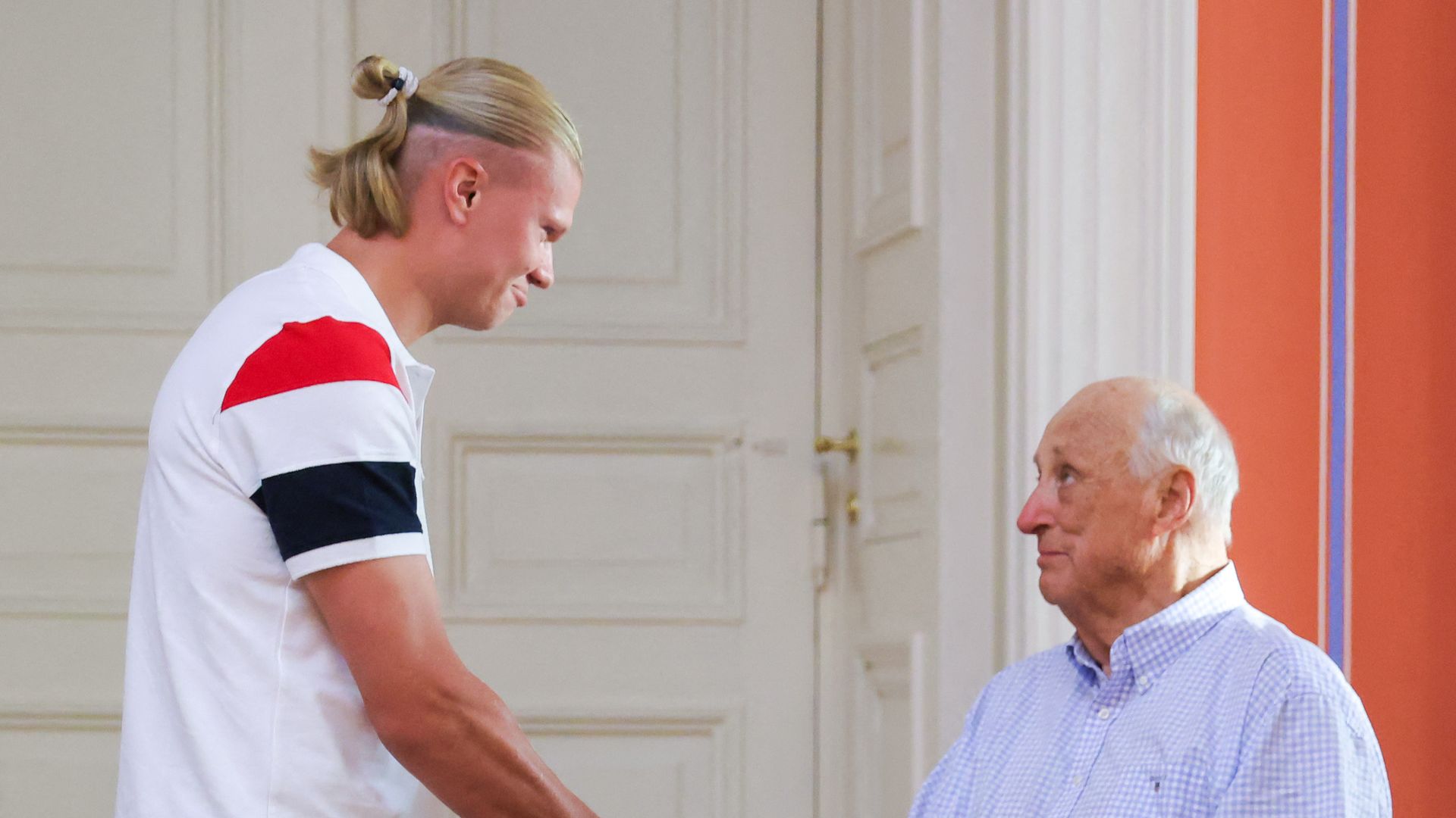 Haaland saludando al rey Harald de Noruega, sentado en un taburete por sus graves problemas de movilidad el pasado 13 de julio